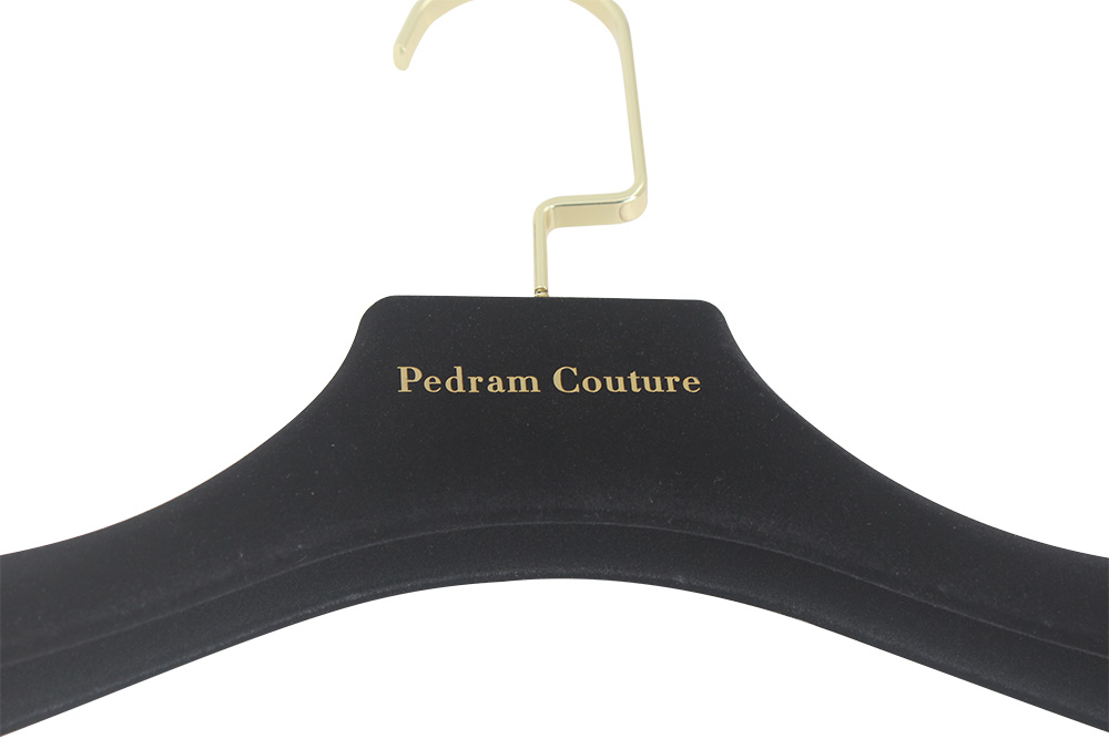 Gold foil logo detail on a black velvet hanger